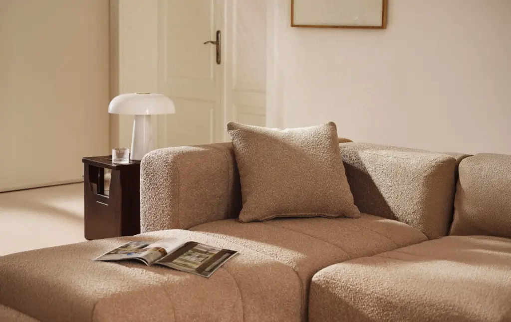 Bouclé-Sofa-Kissen Lena 50×50 cm in Braun auf modularem Bouclé-Sofa im hellen Wohnzimmer
