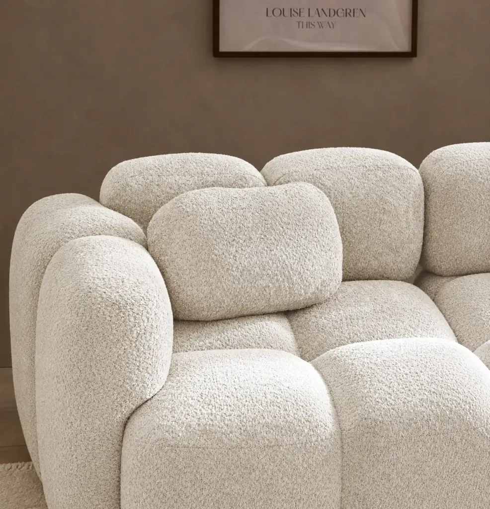 Sofa-Kissen Tayla 36×55 cm aus Teddy-Bouclé in Off White auf modularem Bubble-Sofa vor schokoladenbrauner Wand